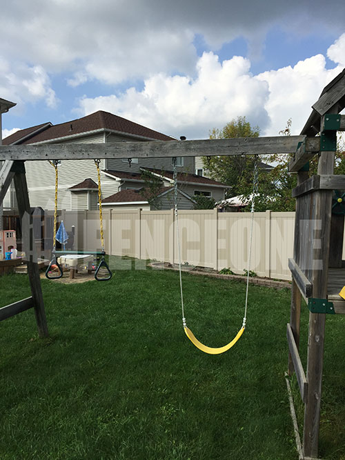 swingset in the backyard with a fence